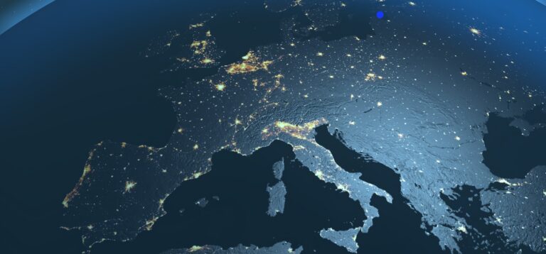 Mapa nocturno de Europa visto desde el espacio, mostrando luces urbanas y relieve terrestre iluminado, con tonos azules y grises. Representa la aplicación de la regulación NIS2.